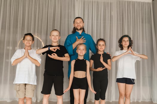 A joint portrait of a yoga coach and children standing in a fitness room photo