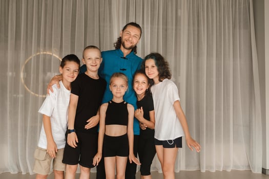 A joint portrait of a yoga coach and children standing in a fitness room photo