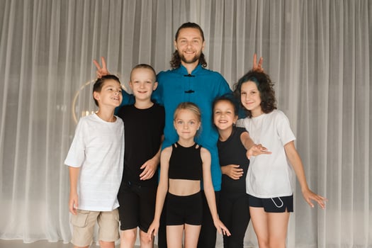 A joint portrait of a yoga coach and children standing in a fitness room photo
