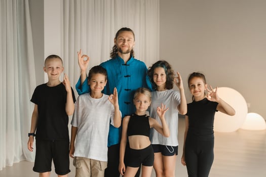 A joint portrait of a yoga coach and children standing in a fitness room photo