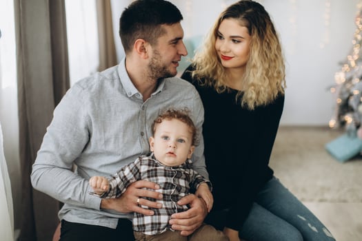 Portrait of happy family of father mother and little curly son celebrating Christmas together at home. photo