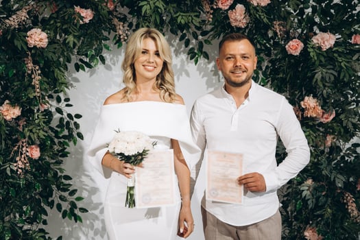 Happy Couple Celebrating Wedding Day with Marriage Certificates in Beautiful Floral Decor photo