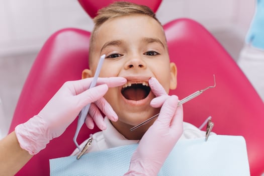 Woman dentist makes a dental examination of the boy mouth photo