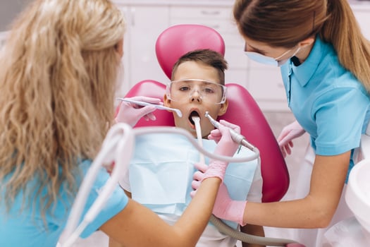 Female dentist treats boy's teeth in dental clinic photo