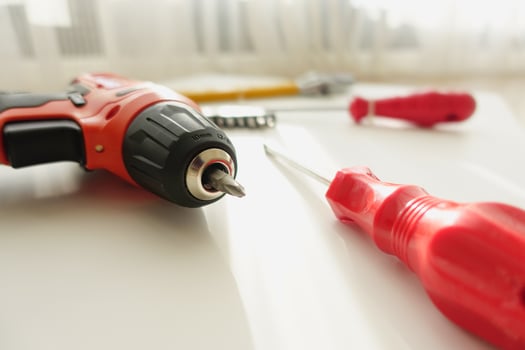 DIY tools and materials are arranged on a wooden floor, illuminated by natural light photo