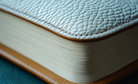 A leather bound book with a tan cover and white pages. The spine of the book is brown photo