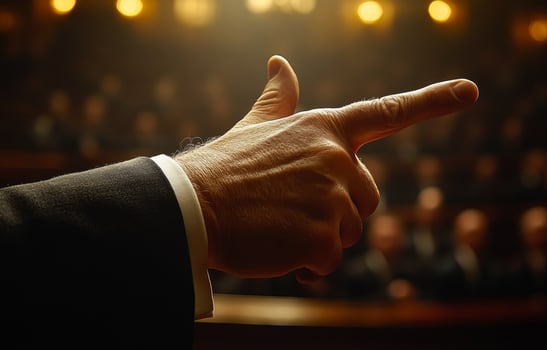 A man pointing his finger at a crowd of people. The man is dressed in a suit and tie photo