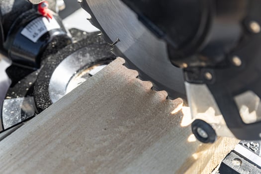 Using a miter saw to cut a piece of wood. Own carpentry workshop. Sawing a wooden board with a miter saw. Safe equipment for the furniture and construction industry. Close-up. photo