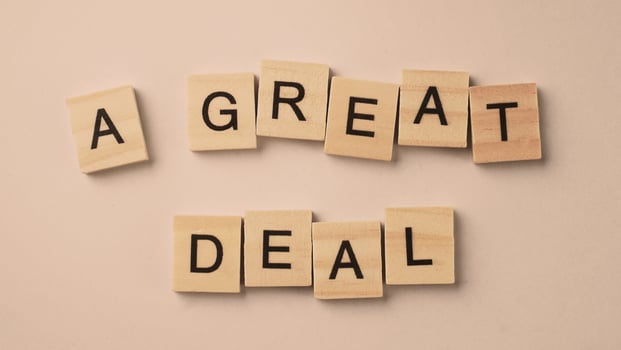 Word of A Great Deal. Text written by wood toy or wood cubes on white paper background photo