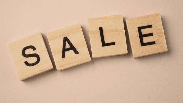 Word of Sale. Text written by wood toy or wood cubes on white paper background photo