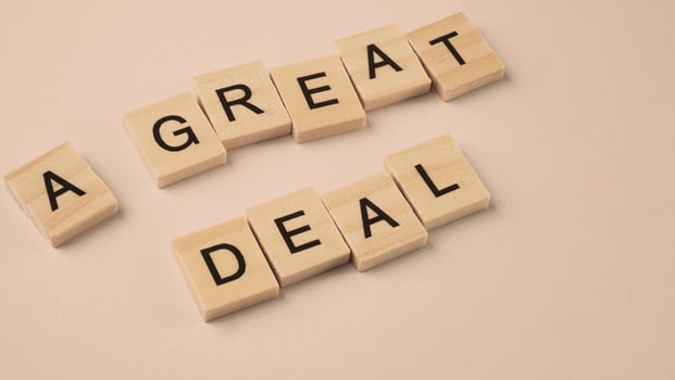 Word of A Great Deal. Text written by wood toy or wood cubes on white paper background photo