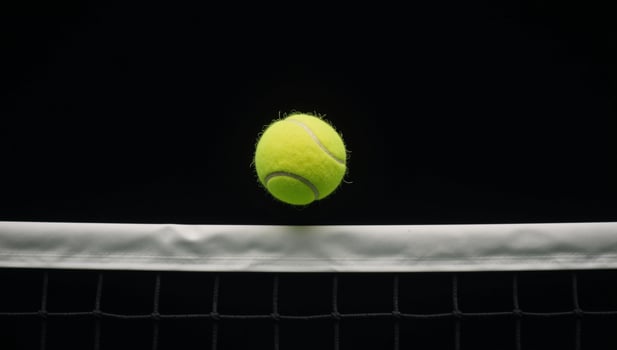 Yellow tennis ball soaring into blackbacked tennis net banner with empty area for text photo