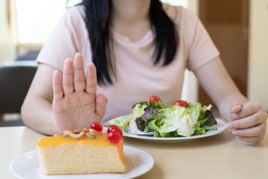 Beauty slim female body confuse desserts. Woman in restaurant achieves weight loss goal for healthy life, crazy about thinness, thin waist, nutritionist. Diet, body shape. photo
