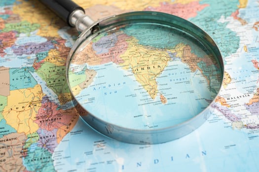 Bangkok, Thailand - June 15, 2024 India, Magnifying glass close up with colorful world map, travel, geography, tourism and exploration concept. photo