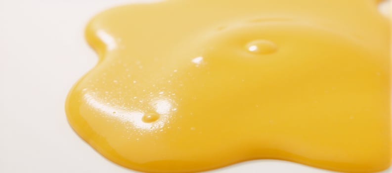 Melted cheese puddle with glossy texture against white backdrop YellowOrange Cheese photo