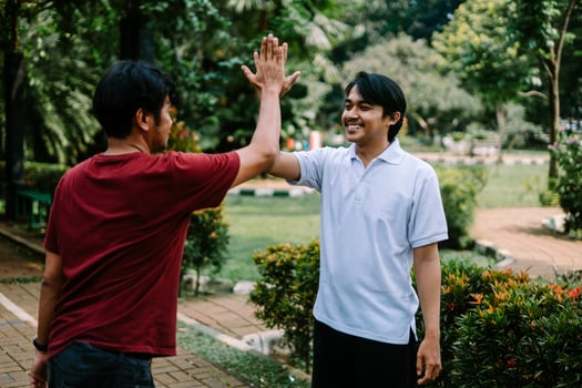 Two Southeast Asian men engaged in a lively conversation at a city square. photo