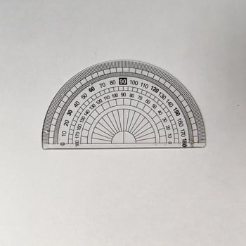 Close-up of a transparent protractor with a 0 to 180-degree scale, placed on a plain white background. This tool is commonly used for measuring angles photo