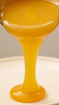 Isolated melted cheese flows downwards in golden hues photo