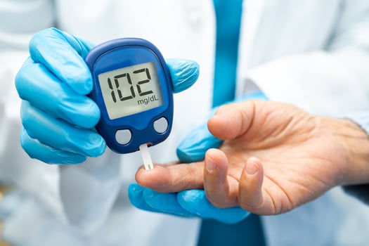 Doctor check diabetes from finger blood sugar level with finger lancet. photo