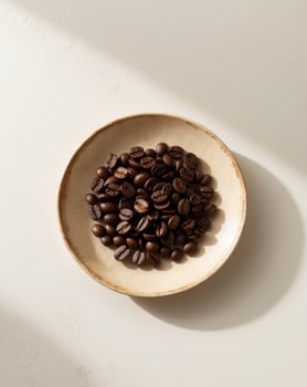 Coffee beans in a bowl on a white surface photo