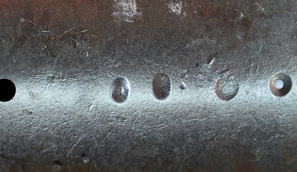Close-up of a rough metallic surface featuring scratches, dents, and weathered texture, ideal for industrial backgrounds. photo