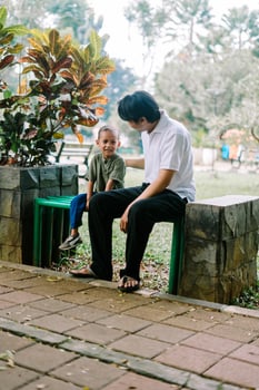 A father and his child sitting and chatting in a city square photo