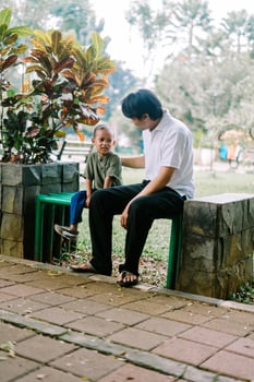 A father and his child sitting and chatting in a city square photo