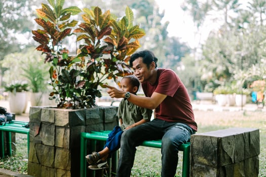 A father and his child sitting and chatting in a city square photo
