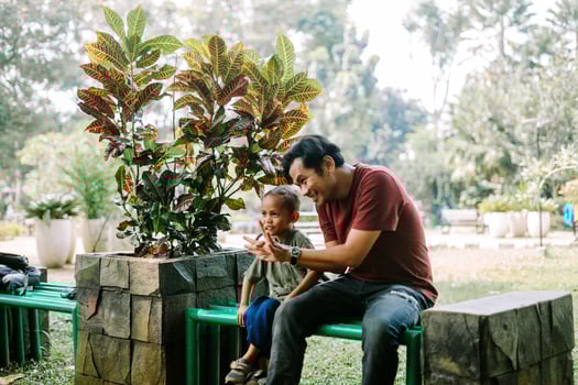 A father and his child sitting and chatting in a city square photo