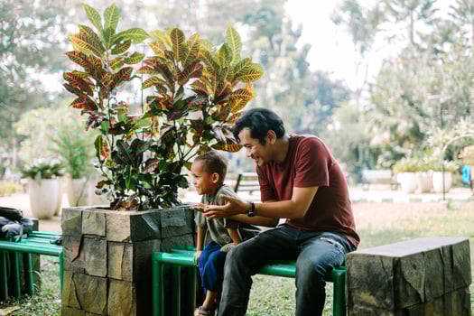 A father and his child sitting and chatting in a city square photo