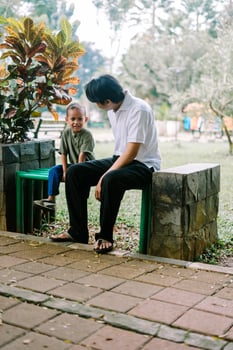 A father and his child sitting and chatting in a city square photo