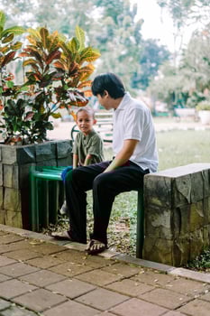 A father and his child sitting and chatting in a city square photo