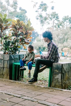 A father and his child sitting and chatting in a city square photo