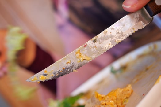 A CloseUp Shot of a Sharp Knife Surrounded by Leftover Food from a Delicious Meal photo