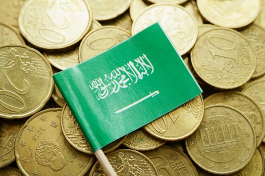 Saudi Arabia flag on coins background, finance and accounting, banking concept. photo