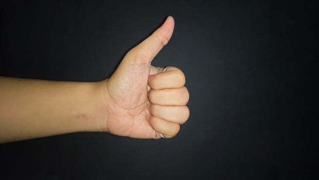 Hand thumb up isolated on black background photo