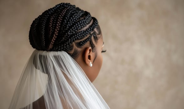 A woman with braided hair wearing a veil with a pearl earring photo