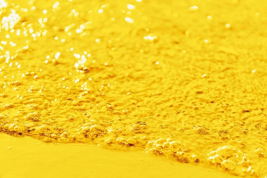 A slow bright golden stream of bubbling liquid photo