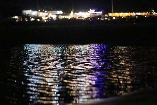 A view of the water at night with lights on photo