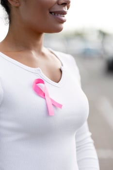 Woman wearing pink ribbon showing support for breast cancer awareness photo