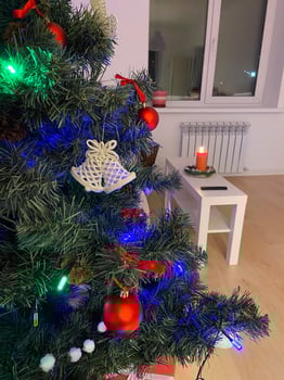 Close-up Festive Christmas tree adorned with colorful lights. Cozy living room and warm holiday atmosphere. photo