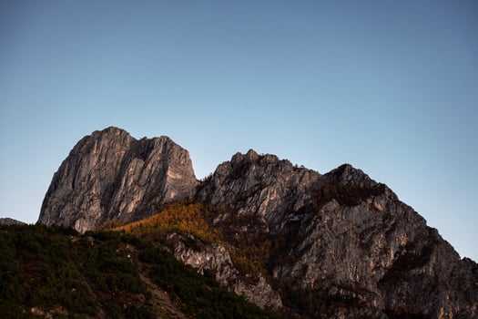 Limestone rock mountain with autumn pine forest and blue sky photo