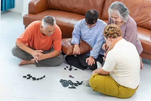 Asian senior man and senior woman playing domino game with grandson, Grandparents and grandson having fun together playing domino game at home photo