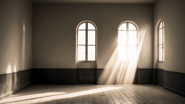 A room with two windows and sunlight streaming through them photo