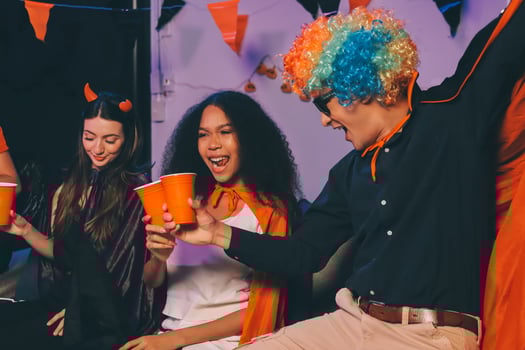 Joyful office Halloween party with coworkers in costumes, celebrating with drinks and laughter, fostering teamwork and festive spirit photo