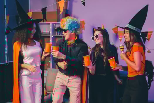 Joyful office Halloween party with coworkers in costumes, celebrating with drinks and laughter, fostering teamwork and festive spirit photo
