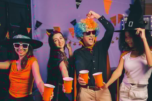Joyful office Halloween party with coworkers in costumes, celebrating with drinks and laughter, fostering teamwork and festive spirit photo