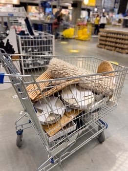 A shopping cart filled with various items in shop photo