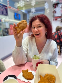 Woman with Japanese sweet taiyaki dessert. Freshly baked fish shaped waffle instead of filling adding ice cream. Winter and Christmas holidays sweets photo
