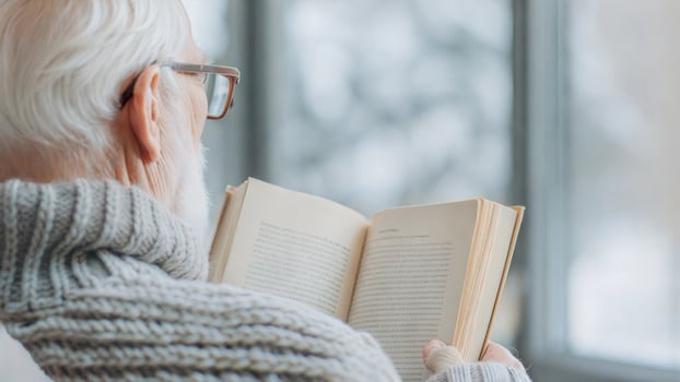 An elderly man is reading a book photo